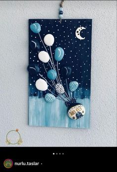 an art piece hanging on the wall with balloons and stars in the sky above it