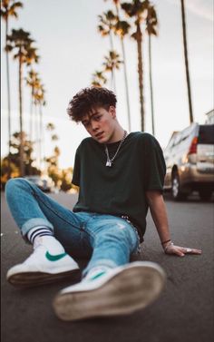 a young man is sitting on the street