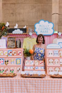 a woman standing in front of a table with many items on it