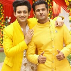 two men dressed in yellow standing next to each other with their arms around one another