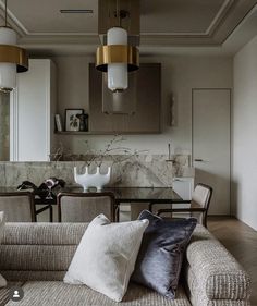 a living room filled with furniture next to a dining room table and kitchen counter top