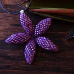 A unique tropical plumeria flower with pointed petals, hand beaded using over 400 tiny ultraviolet purple glass beads, strung and stitched one bead at a time. The flower is sturdy, lightweight, and measures 1.5 inches. Includes an 18-inch black boho-style cord with lobster clasp. © 2019-2021 Heart in Hawaii Matching earrings available; sold separately Also available in other colors; sold separately Professionally handwoven in the US; heirloom quality beadwork Truly unique; exclusive design; dire Purple Flower-shaped Beaded Jewelry, Handmade Silver Beaded Necklaces With Flower Shape, Handmade Silver Flower-shaped Beaded Necklaces, Tropical Plumeria, Lanyard Bracelet, Beaded Charms, Plumeria Flowers, Black Boho, Neon Coral