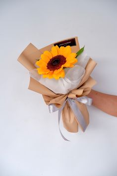 a hand holding a bouquet of sunflowers