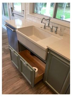 a kitchen sink with an open drawer in the middle and a window to the side