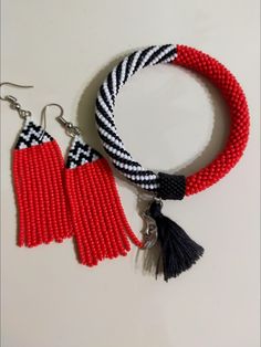 two pieces of red and black beads with tassels