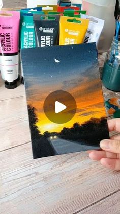 someone is holding up a video card with the sunset in the background and some toothpaste on it