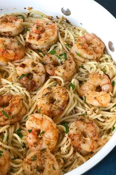 pasta with shrimp and parmesan in a white bowl on a blue tablecloth