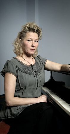 a woman sitting at a piano posing for the camera