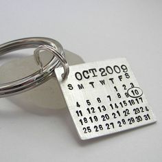 a close up of a metal key chain with a date on the front and numbers on the back