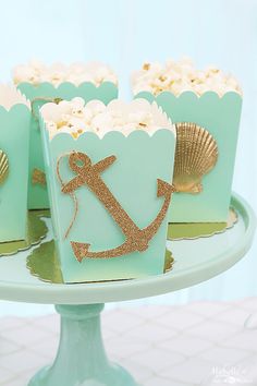 there are cupcakes that have been decorated with an anchor and seashell on them