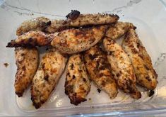 chicken wings in a plastic container with seasoning on the top and bottom side, ready to be cooked