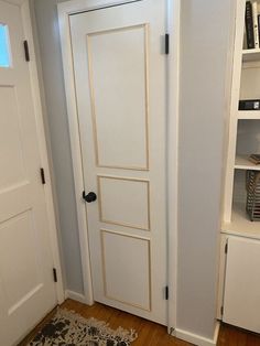 a white door in a room next to a book shelf