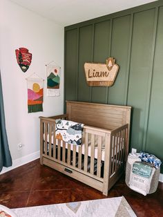 a baby's room with a wooden crib and green painted wall behind it