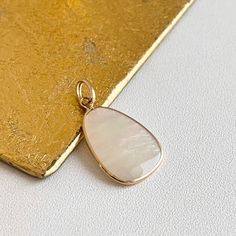 Estate 14KT yellow gold iridescent mother of pearl oblong/ abstract shaped pendant charm. Bail opening: 3mm No chain included Both sides are mother of pearl Measures: 25 x 14mm Not stamped, but guaranteed Polished Mother Of Pearl Pendant Jewelry, Polished Mother Of Pearl Pendant Necklace, Elegant Iridescent Mother Of Pearl Jewelry, Gold Teardrop Pendant Jewelry With High Luster, Elegant Opal Jewelry With Large Pendant, Drop-shaped Mother Of Pearl Jewelry For Gifts, Teardrop Pendant Jewelry With High Luster For Gifts, Mother Of Pearl Drop Jewelry For Gift, Elegant Iridescent Oval Pendant Jewelry