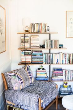 a living room filled with lots of books and furniture