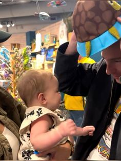 a man holding a baby wearing a hat