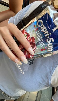 a woman holding onto a bag of chips with cherries on it