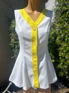 Here is a Vintage 1970s Polyester Head Brand Tennis Dress.Following are the measurements.Bust 34",waist 28",Hips full,length measured from top of shoulder to bottom 28".Buttons up the front.Dress is white with yellow trim running down the front and around the neck.In very nice vintage condition.Please take special consideration of measurements. 1970s sizes were much smaller. Tennis dresses were very short. Not like a regular dress. Barely covers your bottom.So please take note.If you live overse Tennis Dresses, White Tennis Dress, Yellow Trim, Tennis Fashion, Nike Tennis Dress, Womens Sports, Tennis Dress, Vintage Nike, Vintage 1970s