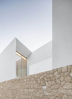 an exterior view of a white house with stone walls and windows on the outside wall