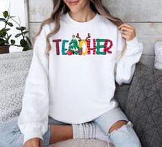 Christmas Teacher Sweatshirt, Teacher Shirt, Christmas Gift For Teacher, Christmas Shirt, Christmas Teacher Gift, Teacher Appreciation Gift HOW TO ORDER Please, Check and Review all Photos. Please choose your size, color and saying separately than add to the card And please do this for each shirt. After that go to the check out and pay together SWEATSHIRT DETAILS - 50% Cotton - 50% Polyester - Medium-heavy fabric (8.0 oz/yd² (271.25 g/m - Shoulder to shoulder taping - Unisex sizing - Runs true to size PROCESSING SHIPPING TIME 1-3 Business Days. Please Double check your address. We are not responsible for items going to the wrong address. If you entered the wrong address, please contact us right away. Addresses cannot be changed once the order is shipped. Standard Shipping (3-5 business day Christmas Teacher Gift, Christmas Gift For Teacher, Sweatshirt Details, Teacher Sweatshirt, Teacher Christmas Gifts, Teacher Appreciation Gift, Teacher Christmas, Gift For Teacher, Gift Teacher