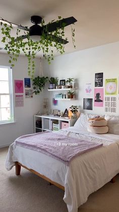 a bedroom with a bed and plants hanging from the ceiling