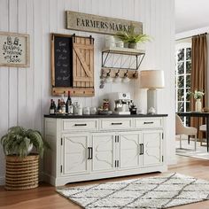 a kitchen with white cabinets and black counter tops next to a rug on the floor