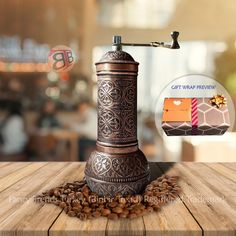 a coffee grinder sitting on top of a wooden table filled with beans and coffee beans