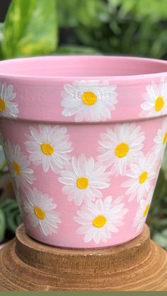 a pink flower pot sitting on top of a wooden stand