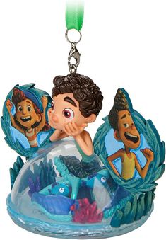 the little mermaid ornament is hanging from a keychain with two small figurines on it