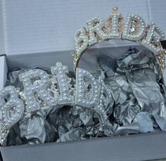 the bride tiara and headpieces are in a box with silver foil on it