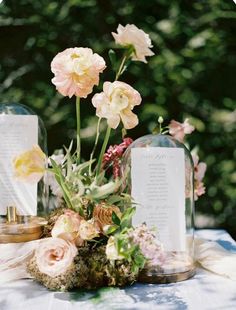 an arrangement of flowers in glass vases on a table