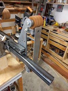 a machine that is sitting on top of a wooden table in a room filled with tools