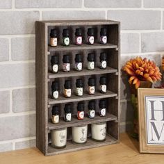 a wooden shelf with many bottles on it next to a sign and potted plant