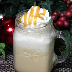 a glass mug filled with liquid and topped with whipped cream