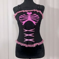 Nwot Dolls Kill Berthaux Skeleton Corset Top Lace Trim Adjustable Straps Black Pink Small This Corset Top Has A Square Neckline, Adjustable Shoulder Straps, A Skeleton Print Across The Chest, Lace Up Ribbon At The Waist, Ruffle Trim, And A Zipper Closure At The Back. Materials Polyester Blend Care Wash According To Care Label Measurements (Flat): Bust: 15” Waist: 12” Length: 19” Gothcore Pink, Skeleton Corset, Skeleton Print, A Skeleton, Clothing Ideas, Care Label, Lace Tops, Corset Top, Dolls Kill