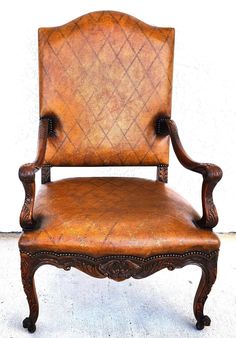 an old leather chair is shown against a white wall