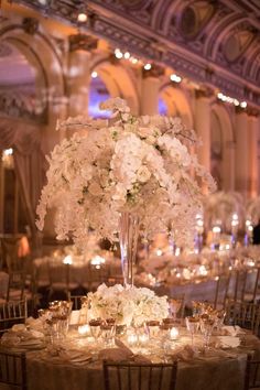 the centerpieces are filled with white flowers, candles and place settings for guests to sit at