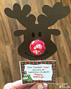 a hand holding up a card with a reindeer head on it and a candy bar in the middle