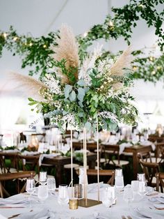 an elegant centerpiece with greenery and white flowers