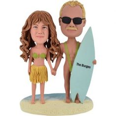 a figurine of a man and woman holding a surfboard