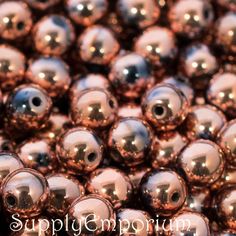 many shiny metal balls are shown in this close up photo with the words supply emporum on it