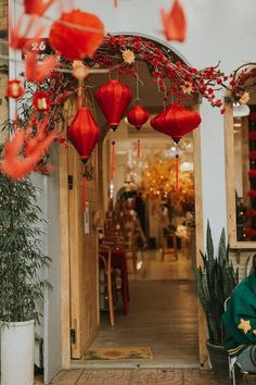 a woman sitting on a chair in front of a building with red lanterns hanging from the ceiling