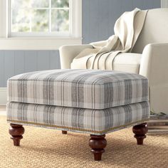 a chair and ottoman in a room with blue walls, carpeted floor and windows