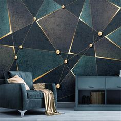 a living room with a blue couch and gold geometric wallpaper