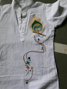 a white shirt with an embroidered peacock on it