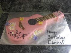 a birthday cake with a pink guitar on it