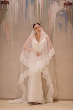 SYDNEY | Ruffled edged drop veil Sydney is a modern, luxurious, statement wedding veil made with luxurious soft English tulle, sometimes known as English net (imported from England). This silk style soft tulle creates a dramatic silhouette with lots of drape and zero stiffness. This veil is a two layers drop veil with a double layer ruffled edge. The frills measures 15 cm. The blusher is 30'' long. The veil is attached to a metal wire comb. The silk style tulle is available in pale ivory and tru Ruffle Veil Wedding, Elegant Ruffled Tulle Fabric For Wedding, Elegant Wedding Tulle Fabric With Ruffled Skirt, Ruffled Tulle Fabric For Wedding, Wedding Tulle Fabric With Ruffles, Ruffle Veil, Chapel Length Veil, Dramatic Silhouette, Drop Veil