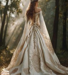 a woman in a wedding dress standing in the woods