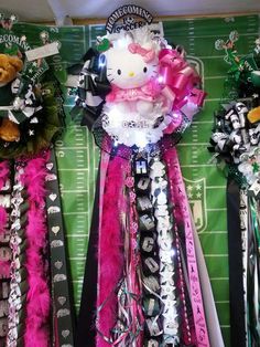 hello kitty decorations on top of a football field with pink, black and white ribbons