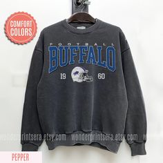 Vintage Style Comfort Colors Sweatshirt, Buffalo Bill Sweatshirt, Bill Sweatshirt, Bills Football, Buffalo New York, Buffalo Fan Gift ⭐𝐐𝐔𝐀𝐋𝐈𝐓𝐘: At Wonder Prints Era our brand believes in using the best materials to create our designs. Unlike many other shops using Gildan shirts that wear out quickly. We use luxury fabric and ink to make our products. Our designs are proudly Printed on Comfort Colors® tees/sweatshirts for that insanely soft, vintage look and feel and they meant to last. On Winter College Tops With Lettering, Lettering Tops For College In Winter, Team Spirit Graphic Print Winter Tops, Winter Team Spirit Graphic Print Tops, Collegiate Winter Tops With Text Print, Sports Season Crew Neck Tops With Lettering, Crew Neck Tops With Lettering For Sports Season, Long Sleeve Tops With Text Print For Fan Gear, Team Spirit Long Sleeve Top With Lettering